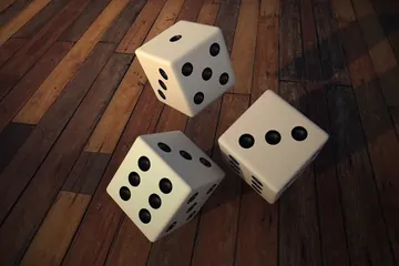 ثلاثة أحجار نرد على سطح خشبي